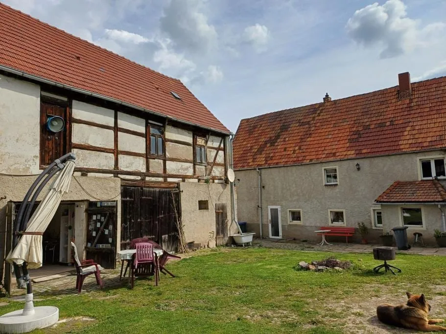 Foto des Vierseitenhofs Am Erlengrund 6 vor der Sanierung: Innenhof mit dem Fachwerk-Obergeschoss des Seitengebäudes.