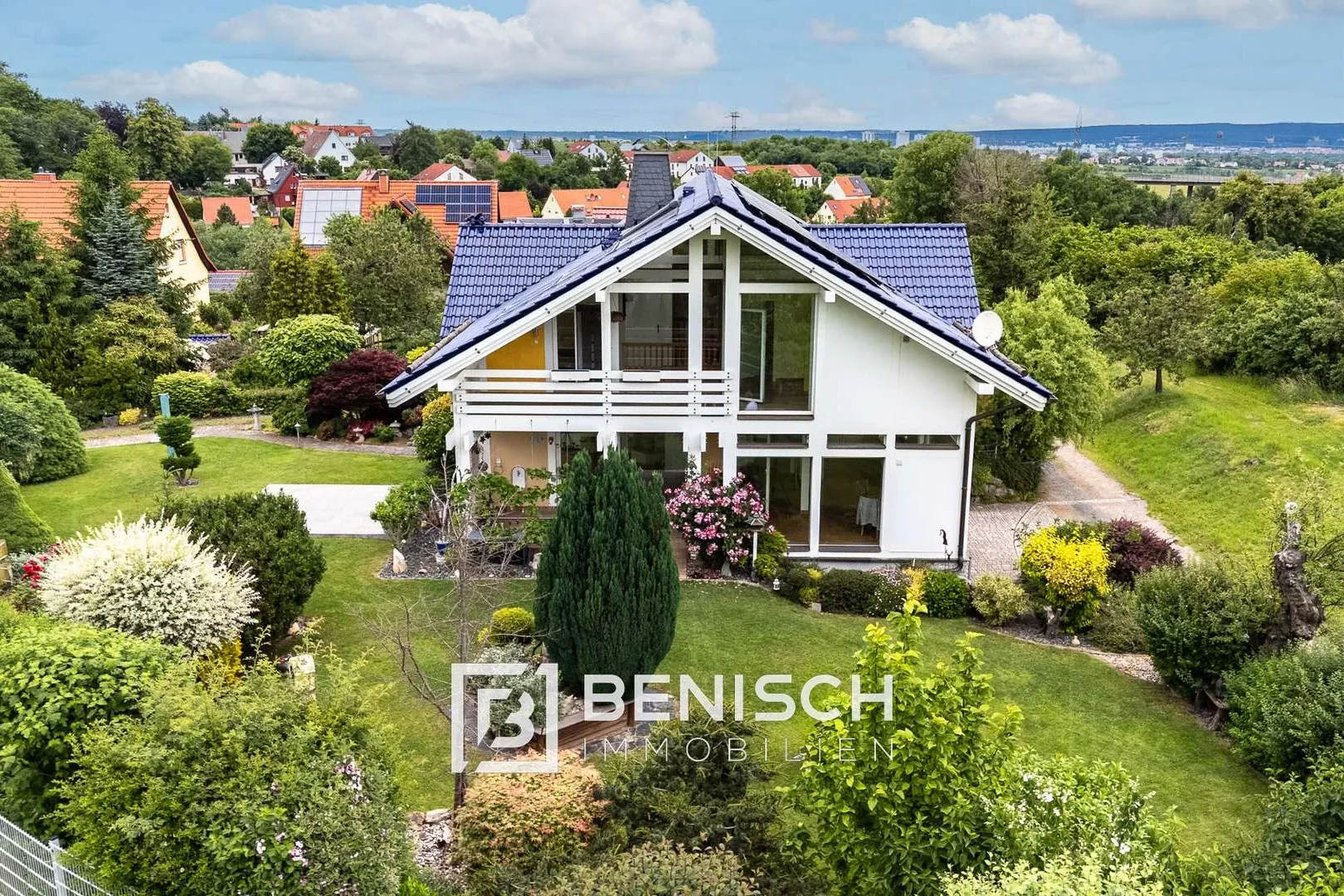 Von Benisch Immobilien verkauftes Einfamilienhaus in Bannewitz bei Dresden – Haus mit Glasgiebel und parkartigem Garten, im Hintergrund die Stadt
