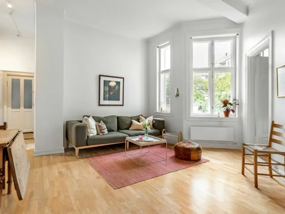 Helles Wohnzimmer einer Altbauwohnung mit hohen Fenstern