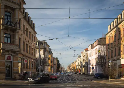 Gründerzeitliche Häuserzeilen in Dresden-Löbtau, aufgenommen an der Kesselsdorfer Straße: Straßenbahngleise mit Oberleitung, links ein Eckhaus mit Apotheke im Erdgeschoss.