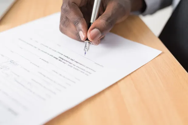 Unterschrift eines Kaufvertrags mit Füllfederhalter – erst die notarielle Beurkundung macht den Immobilienverkauf wirksam